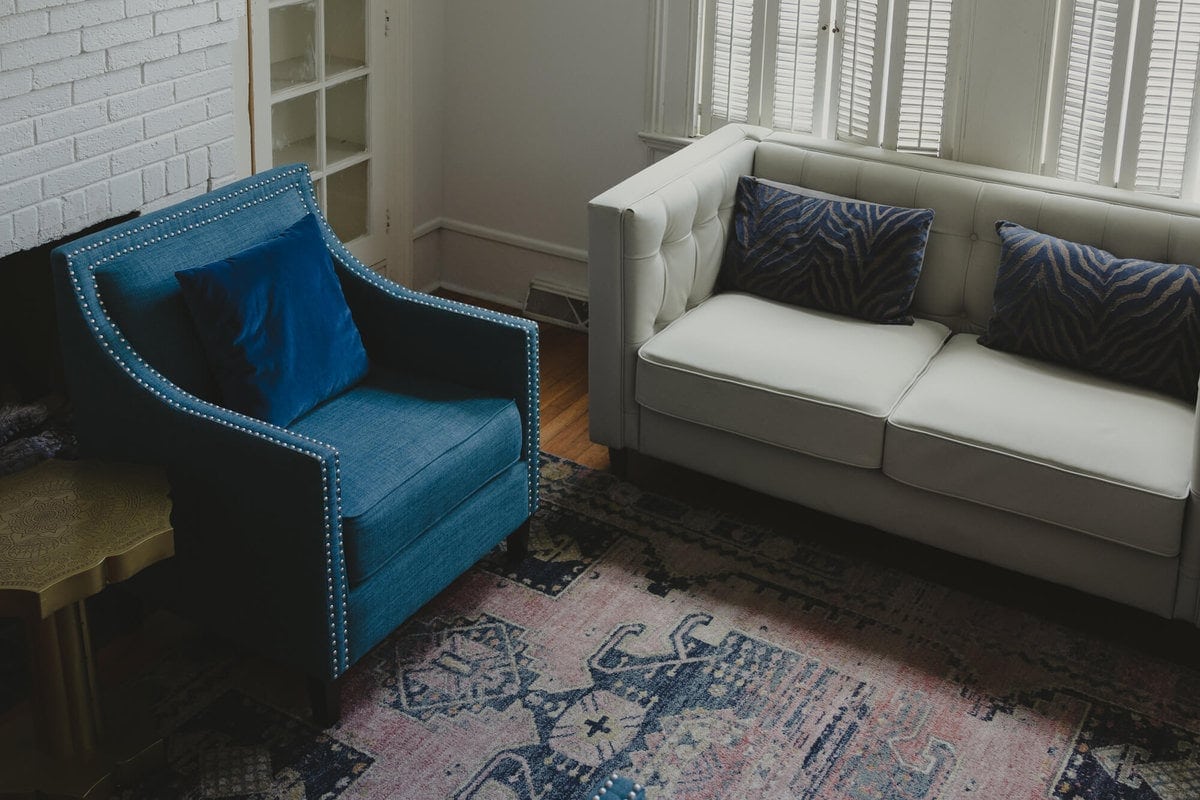 Blue armchair and white tufted sofa in a Columbia counseling room