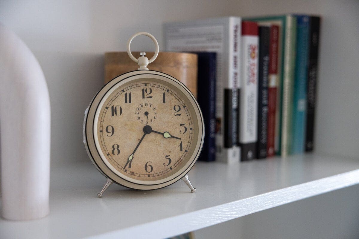 Round alarm clock and therapy books on a shelf in the Lexington office
