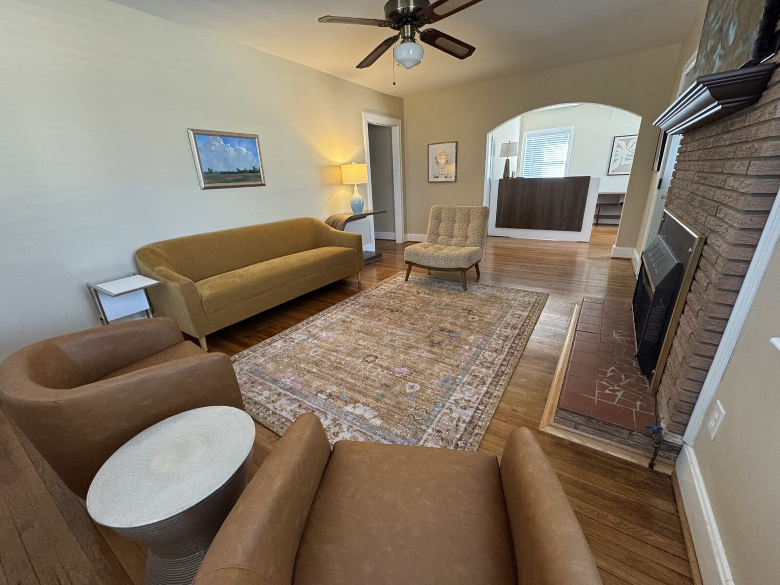Blythewood office lobby with a mustard sofa, brick fireplace, and reception desk