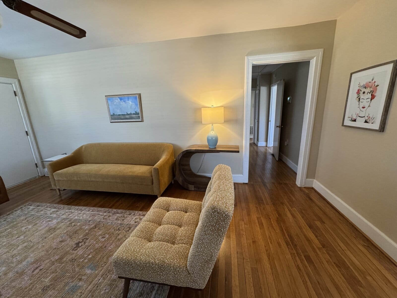 Blythewood waiting area with a mustard sofa, patterned chair, and hardwood floors