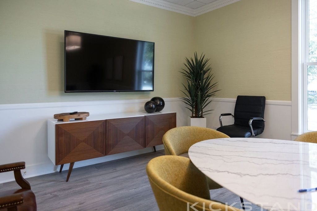 Columbia meeting room with a marble table, mustard chairs, and a wall-mounted television