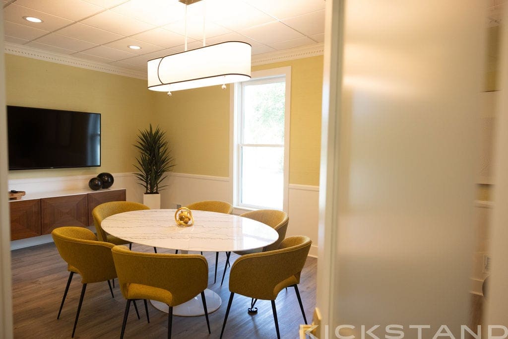 Round marble table and mustard chairs in the Columbia meeting room