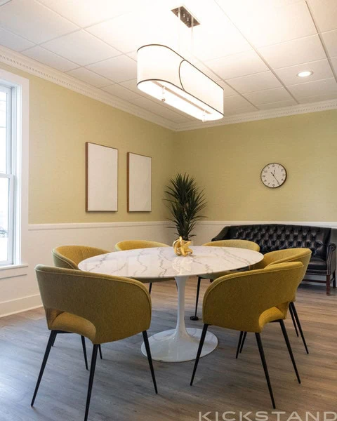 Columbia meeting room with mustard chairs, a black bench, and a pendant light