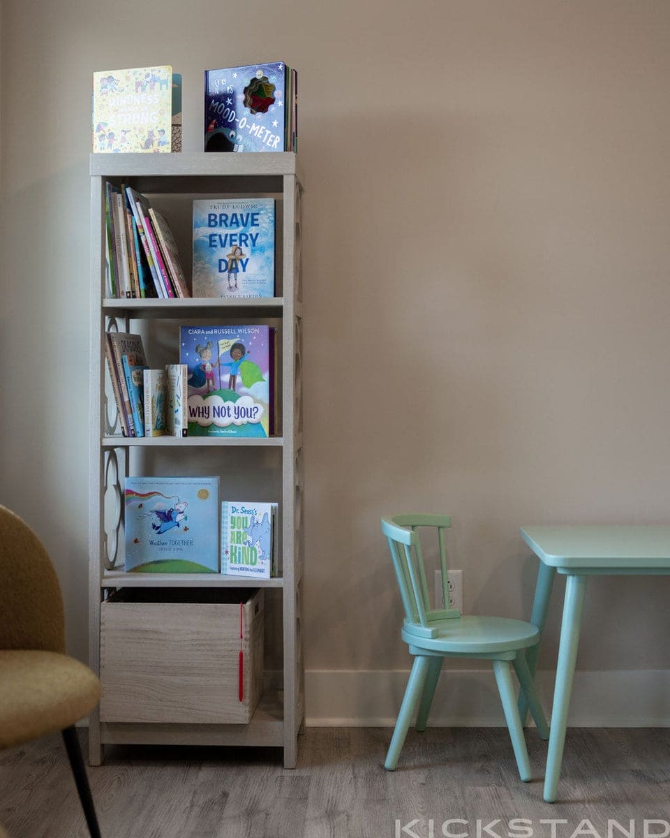Children’s bookshelf and small teal table in the Columbia office