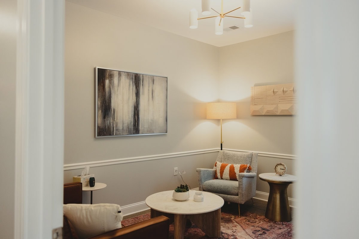 Lexington counseling room with a gray armchair, coffee table, and abstract painting