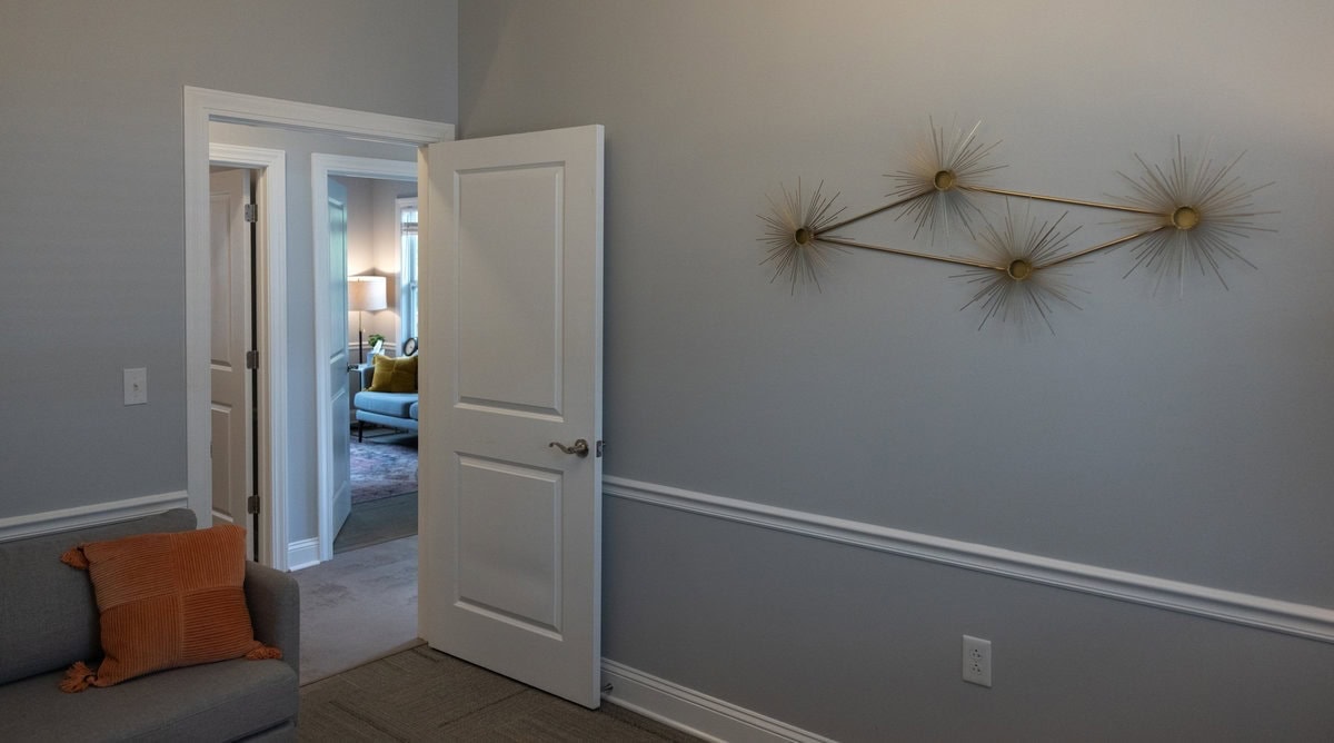 Open door between Lexington counseling rooms, with a gold starburst sculpture on the wall