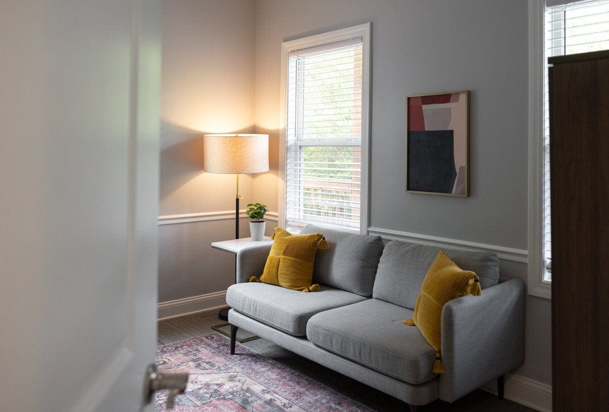 Gray sofa with mustard pillows in a Lexington counseling room