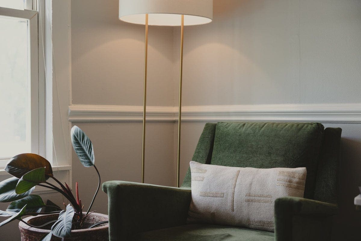 Green velvet chair and floor lamp in a Lexington session room